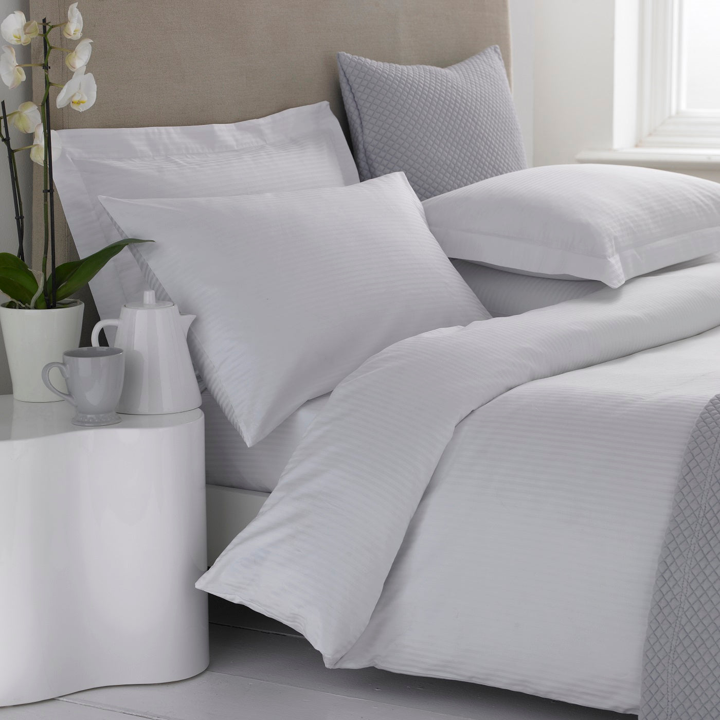 A white Egyptian cotton sateen duvet cover with a micro-stripe pattern, displayed on a bed with matching pillows and bedding.