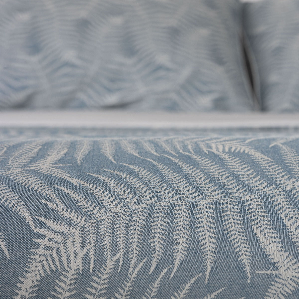 Close-up of blue fabric with a subtle pattern, possibly a curtain or upholstery.