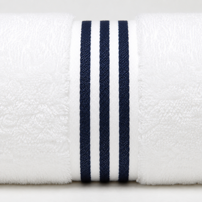 A close-up of a white textured towel roll featuring three vertical navy blue stripes on the front edge.