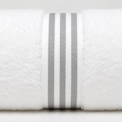 A close-up of a white textured towel rolled up, featuring three vertical gray stripes around the center.