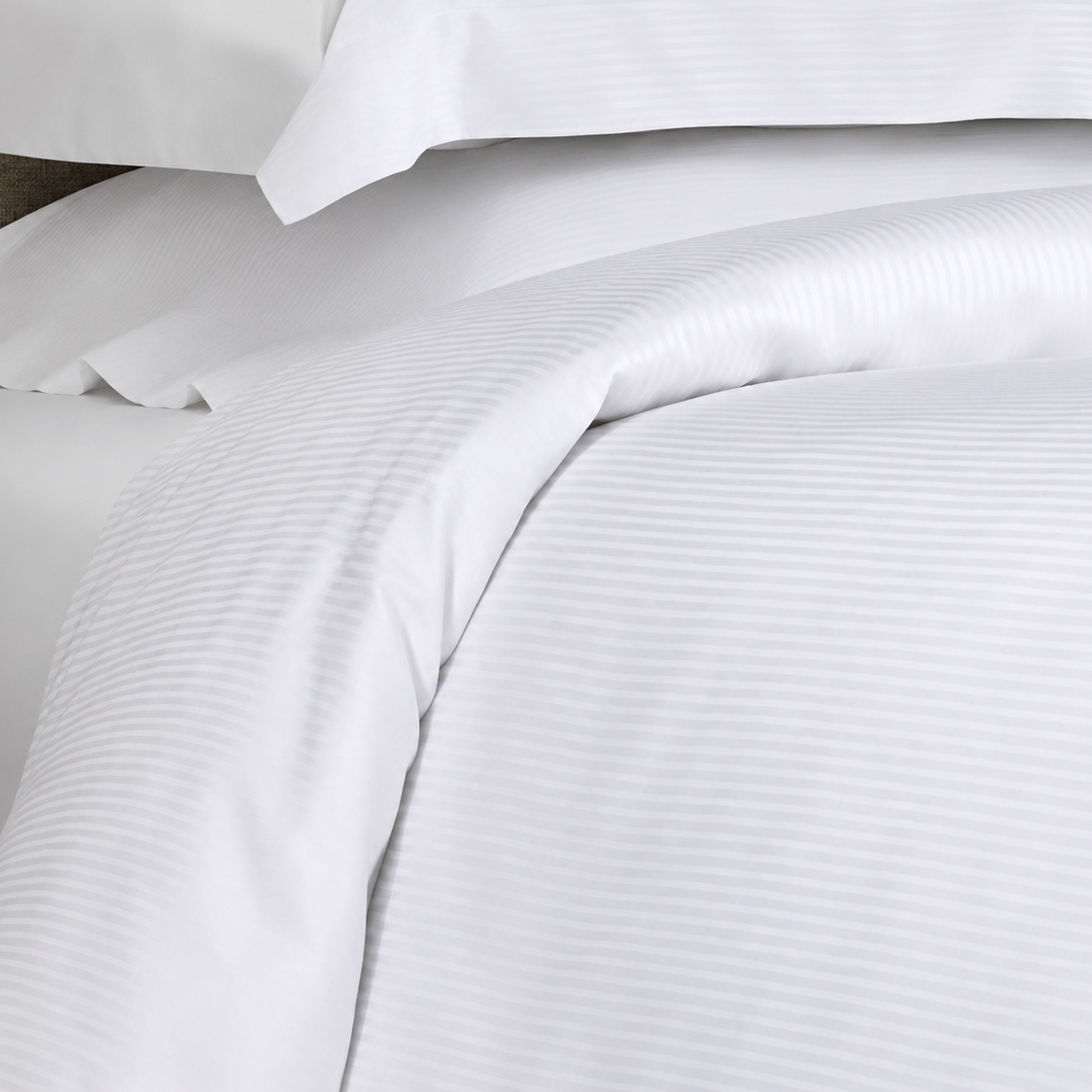 White striped bedding set including a duvet cover and matching pillowcases, shown in a close-up view highlighting the fabric texture.