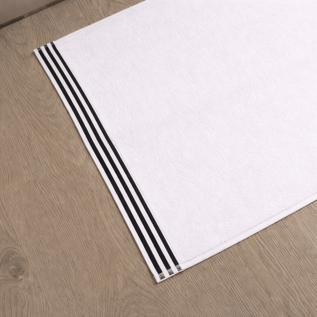 White towel with black stripes on a wooden floor