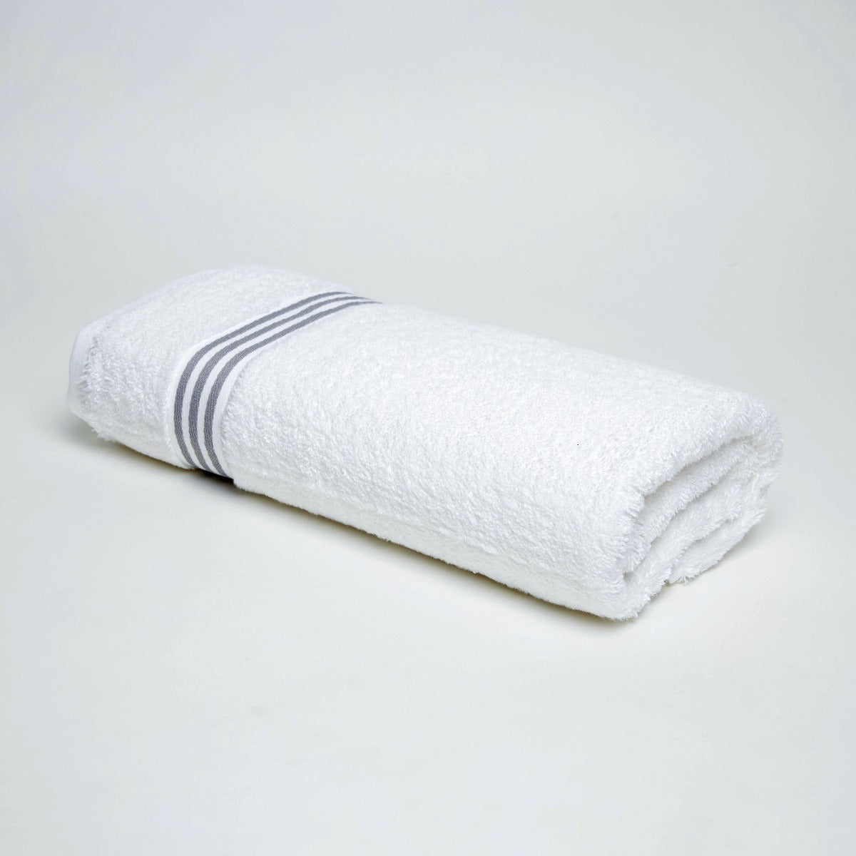 King of Cotton Folded white Milano towel 700gsm with 3 grey stripes on a light grey background