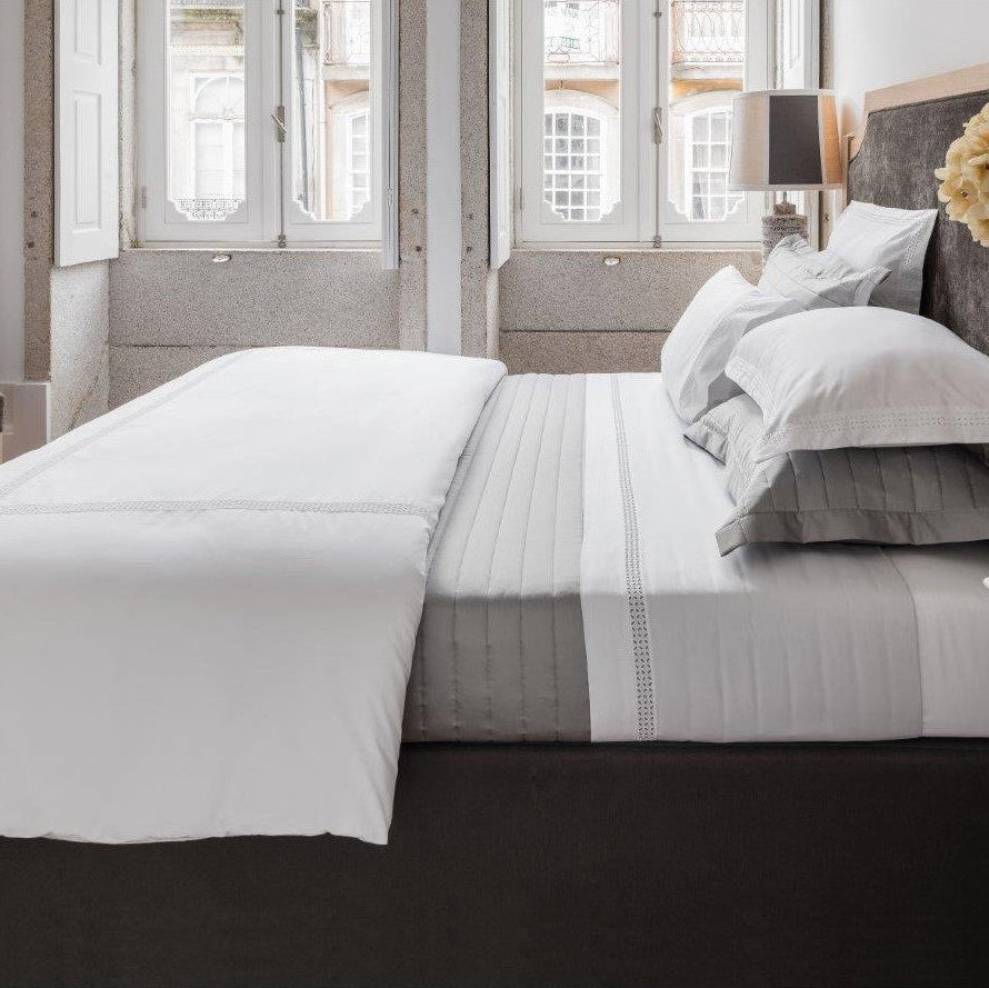 Bed with gray and white bedding in a bedroom setting